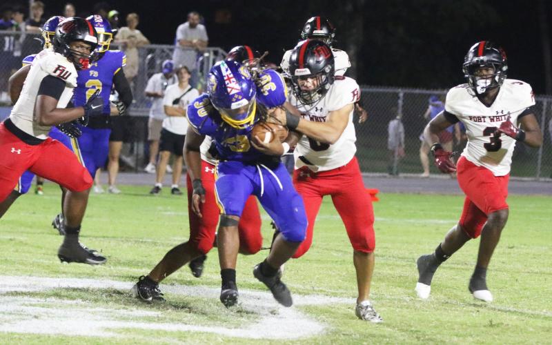 Fort White defensive back Ezekiel Powell tackles Fernandina Beach running back Traivon Martin on Friday. (MORGAN MCMULLEN/Lake City Reporter)