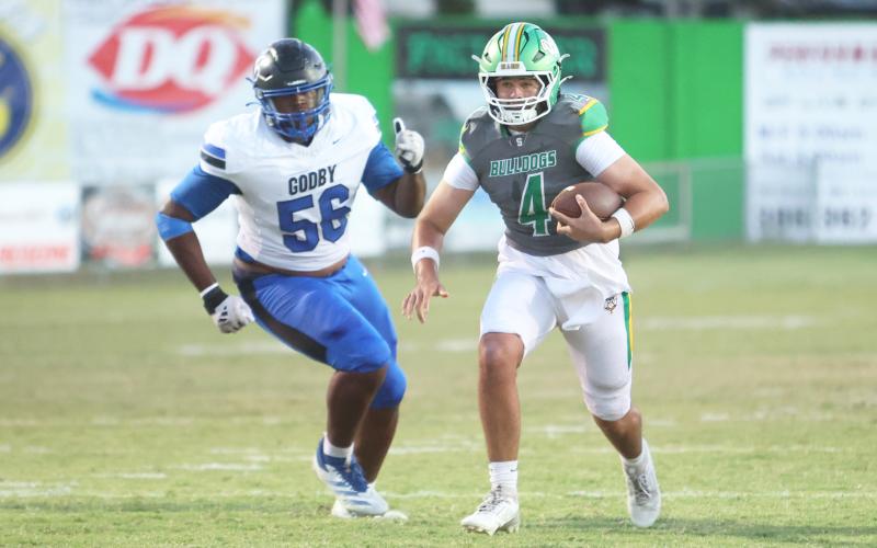 Suwannee quarterback Thomas Sikes scrambles away from pressure against Godby last Friday. (PAUL BUCHANAN/Lake City Reporter)