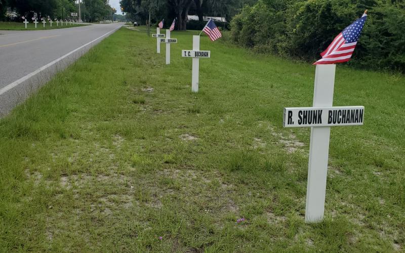 Crosses and flags line County Road 53 in Day several years ago. The crosses in honor of veterans will go up Monday there and on Tuesday by the Masonic Lodge in Mayo. (COURTESY)