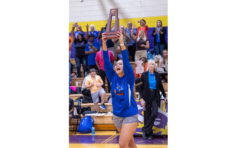 Branford coach Lachelle Sikes celebrates as she delivers the District 6-R trophy to her team following their victory over Union County on Oct. 16. (JACK HOWDESHELL/Lake City Reporter)