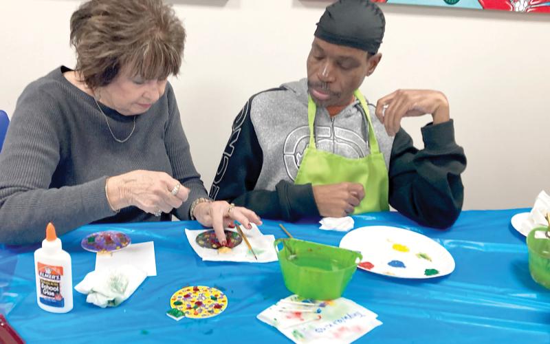 Gateway Art Gallery artist Jeanne Van Arsdall discusses design with CARC painter Tony Lovett. (COURTESY)