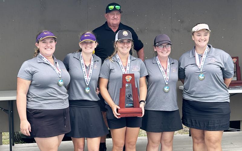 Columbia’s girls golf team smiles with the District 2-2A trophy on Tuesday. (COURTESY)