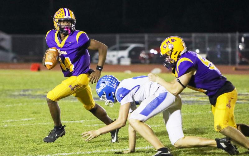 Columbia quarterback Xavier Collins scrambles away from pressure during Friday’s win over Clay. (BRENT KUYKENDALL/Lake City Reporter)