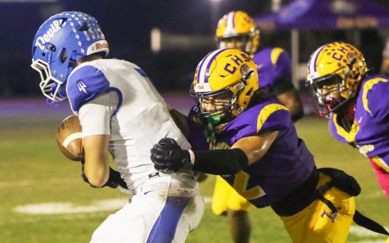 Columbia safety Julian De La Cruz dives to tackle Clay quarterback Landon Martin on Friday. (BRENT KUYKENDALL/Lake City Reporter)