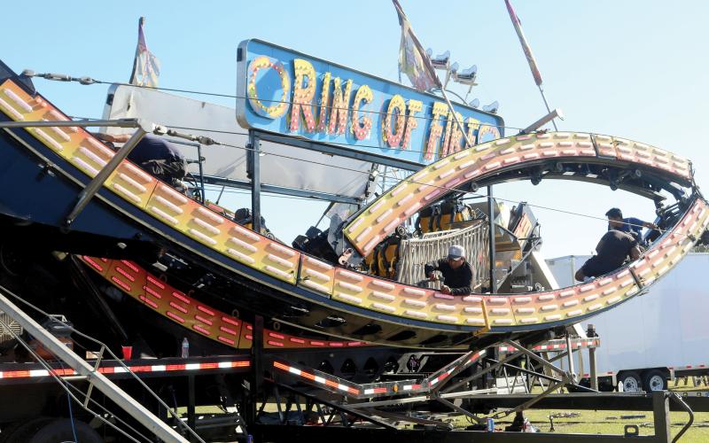 Workers get set on constructing the Ring of Fire, one of the many attractions coming this weekend as the 71st annual Florida Gateway Fair opens at the Florida Gateway Fairgrounds on Friday. (TONY BRITT/Lake City Reporter)