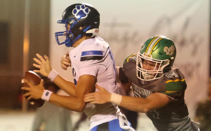Suwannee defensive end Kyler Watson pressures Godby quarterback Landon Dougherty on Sept. 12. (PAUL BUCHANAN/Lake City Reporter)