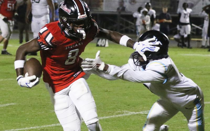 Fort White receiver Jayden Jackson stiff-arms a Zarephath Academy defender Friday night. (MORGAN MCMULLEN/Lake City Reporter)