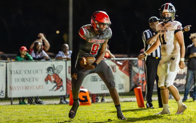 Lafayette quarterback Tywan Williamson reacts after scoring the Hornets’ first touchdown against Fort White on Friday night. (JACK HOWDESHELL/Lake City Reporter)