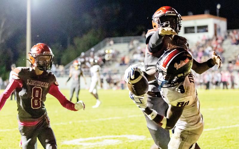 Fort White receiver Jayden Jackson hauls in a touchdown catch behind Lafayette defenders Parker Hill (8) and Tywan Williamson on Friday night. (ACK HOWDESHELL/Lake City Reporter)