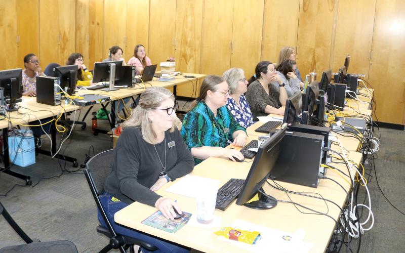 Columbia County Public Library Director Katrina Evans (left) and other library staff members sit through training in the main branch library as the library prepares to launch a new website and system. (TONY BRITT/Lake City Reporter)