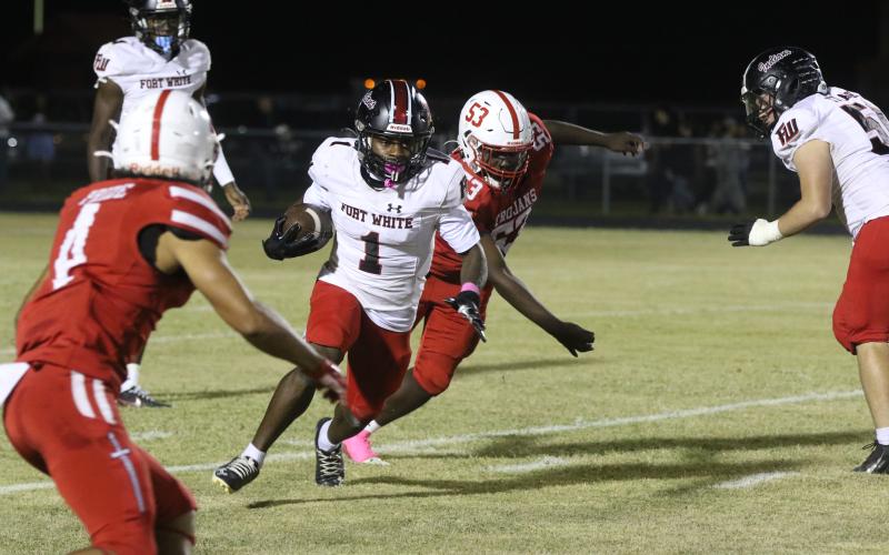 Fort White running back John’l Lawson looks for room up the sideline against Hamilton County on Friday. (MORGAN MCMULLEN/Lake City Reporter)