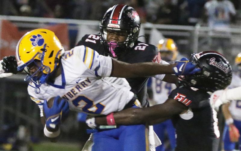 Newberry running back Kaleb Woods stiff-arms Fort White defensive back Jayden Jackson during Friday’s 25-7 loss. (MORGAN MCMULLEN/Lake City Reporter)