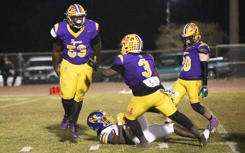 Columbia defensive tackle Jaden McCray (53) celebrates with defensive end Terry Henry (3) and linebacker Bryson Grinstead (20) after stuffing Rickards running back Karlise Price for a loss during Friday’s Region 1-4A quarterfinal. (BRENT KUYKENDALL/Lake City Reporter)