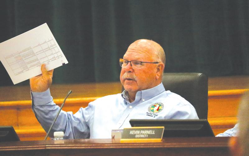 Columbia County Commissioner Rocky Ford holds up a document during the discussion about whether to renew the contract with WastePro on solid waste collection or go back out to bid. (JAMIE WACHTER/Lake City Reporter)