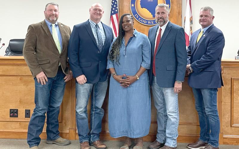 Gigi Gwinn, the widow of Donnell Gwinn, is pictured with Suwannee County Commissioners Leo Mobley (from left), Don Hale, Chairman Travis Land and Franklin White after they passed a proclamation in her late husband’s honor. The county also plans to name a new building at the fairgrounds after Donnell Gwinn. (JAMIE WACHTER/Lake City Reporter)