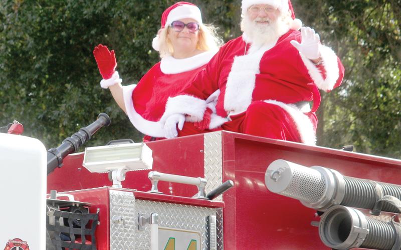 Santa and Mrs. Claus wave from a Columbia County Fire Rescue truck during last year’s Fort White Christmas parade. (FILE)