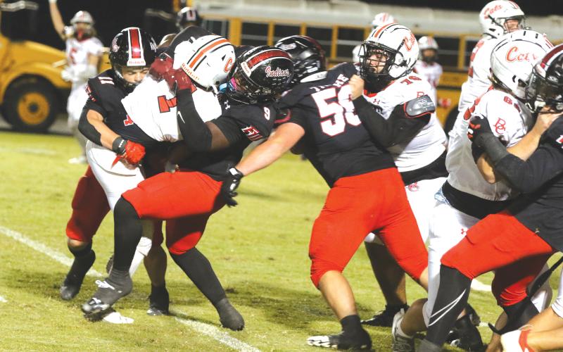 Fort White defensive end Josiah Harmon (9) and linebacker Teagan Bell combine for a tackle on Baker County’s Delynno Ruise in Friday’s 19-7 win. (MORGAN MCMULLEN/Lake City Reporter)