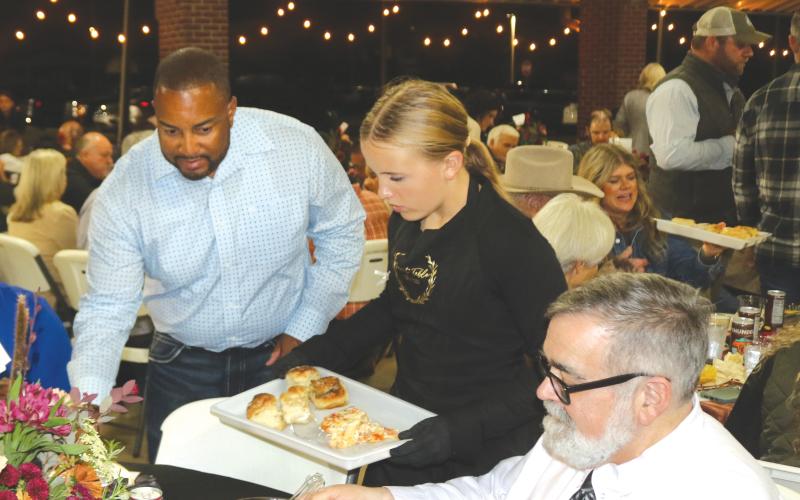 Weslyn Feagle (center) provides lasagna and garlic knots for Columbia County Commissioner Kevin Parnell (left) and County Manager David Kraus during Thursday night’s Farm to Table event at Darby Pavilion. (TONY BRITT/Lake City Reporter)