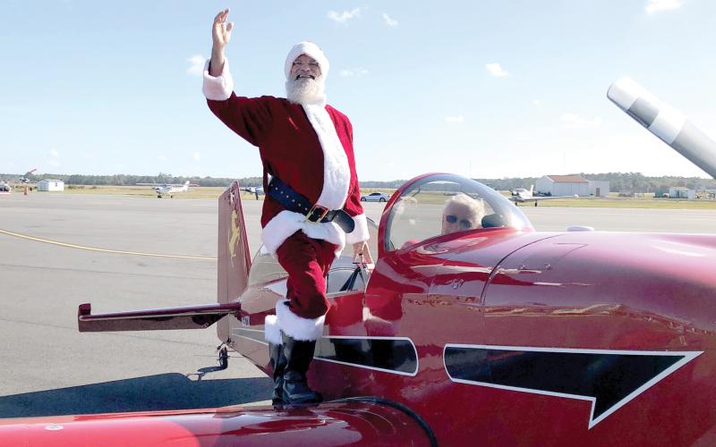 Santa Claus waves after landing in an airplane at the Lake City Gateway Airport for the inaugural Pilots With Presents Fly-In in 2023. (FILE)