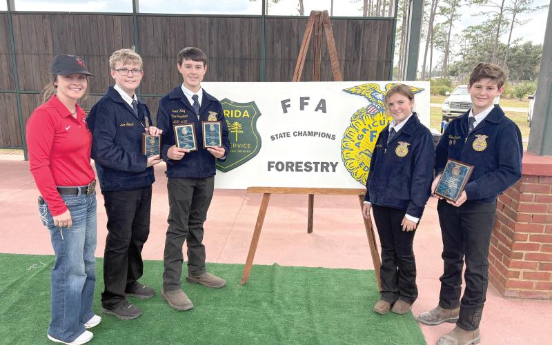 Lafayette Middle FFA won its fourth state forestry title in five years Nov. 6 at the Florida Forest Festival Grounds in Perry. State champion team members were Miles Jackson, Brock King, Alex Stewart at Madison Ward. They are pictured with FFA Advisor Tori Lyons. (COURTESY)