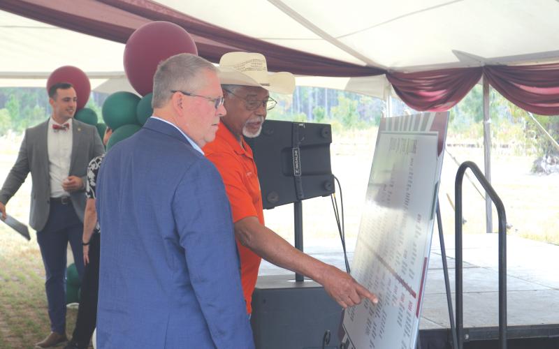 Former Columbia County Commissioner Ron Williams (right) points out a moment on the timeline of the North Florida Mega Industrial Park to Rep. Chuck Brannan during Thursday’s celebration. (TONY BRITT/Lake City Reporter)