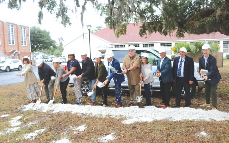 Tossing dirt to celebrate the construction of a new private fiber network for the school district were: Cindy Forsyth (from left), Jay Duval, Denise Weybrew, Hope Jernigan, Todd Widergren, Dana Brady-Giddens, Patrick Mitchell, Keith Couey, Cherry Hill, Jesus Pena, Billy Merchant and Oliver Landow. (TONY BRITT/Lake City Reporter)