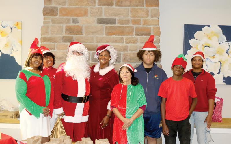 Tammy Harris (from left), Kathy Dix, Bo Beauchemin, Befaithful Coker, Judith McClure, Malachi Thompson, Michael Coker and Victoria Coker, members of It’s About My Efforts, which is part of the Our Community Cares Coalition, visited assisted living facilities on Sunday giving senior citizens goodie bags and other items. (TONY BRITT/Lake City Reporter)