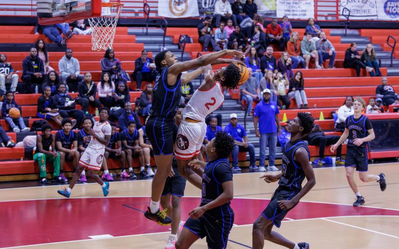 Fort White guard Desean Lally has his shot blocked by Newberry forward Brandon Kelly on Friday. (JACK HOWDESHELL/Lake City Reporter)