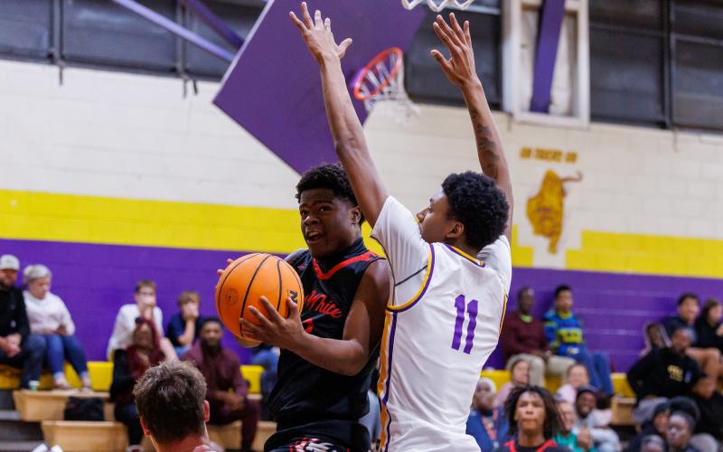 Fort White guard X’Zaevion Gibson drives to the basket while defended by Union County center Adrian Manns on Friday. (JACK HOWDESHELL/Lake City Reporter)