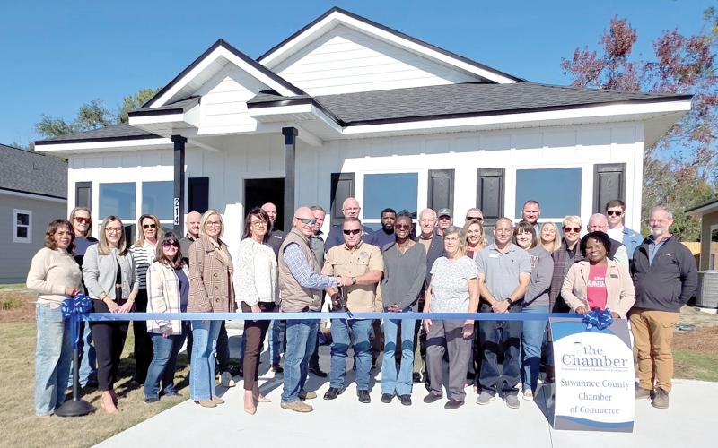 Milton Smith and Darren Webb with GSMS Developers cut the ribbon in front of one of the new houses in the Canyon Vistas subdivision in Live Oak. GSMS evelopers was joined at the ribbon cutting by Suwannee County Chamber of Commerce represenatatives as well as Suwannee County and City of Live Oak officials. (MONJA SLATER/Lake City Reporter)