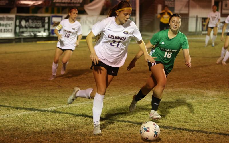 Columbia's Laelle Thompson dribbles the ball up the field as Suwannee's Maylee Grantham pursues her on Nov. 20. (PAUL BUCHANAN/Lake City Reporter)