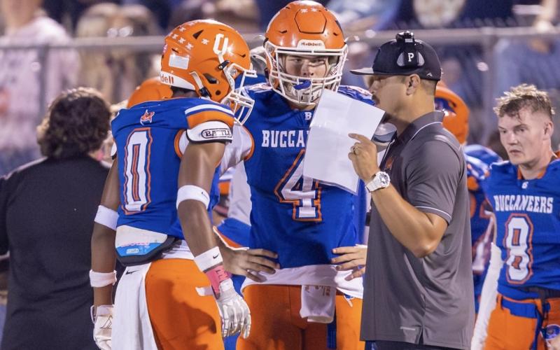 Branford coach Tim Clark (right) speaks to quarterback Trent Land (4) and receiver Maurice Vought (0) during a game this past season. (JACK HOWDESHELL/Lake City Reporter)