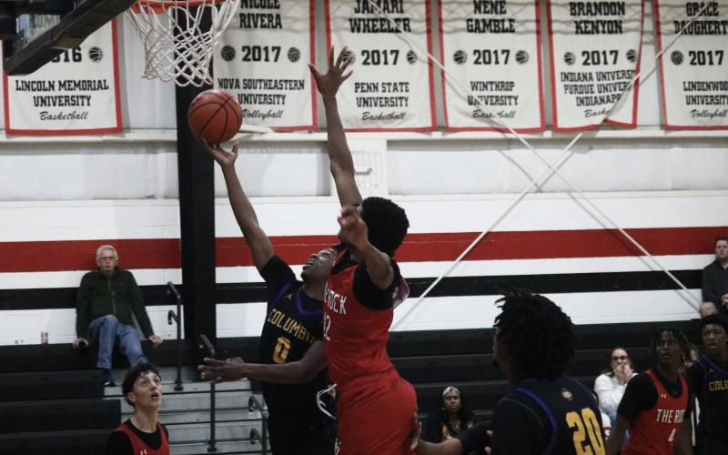 Columbia guard Murkail Cray (0) tries to get a shot off while defended by The Rock center Jafari Hicks on Tuesday. (JORDAN KROEGER/Lake City Reporter)