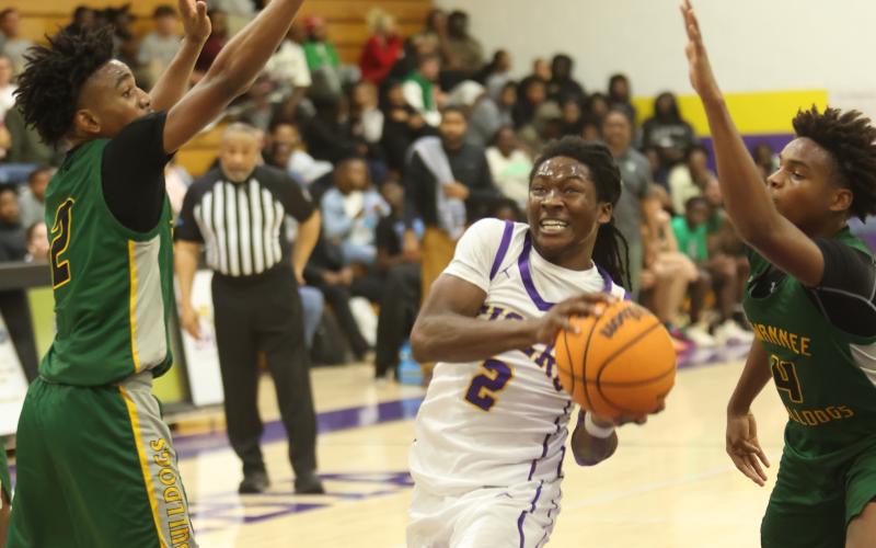 Columbia guard Kadrian Wilson drives between Suwannee guards Jalen Hampton (2) and Kamarien Smith (4) on Dec. 12. (PAUL BUCHANAN/Lake City Reporter)