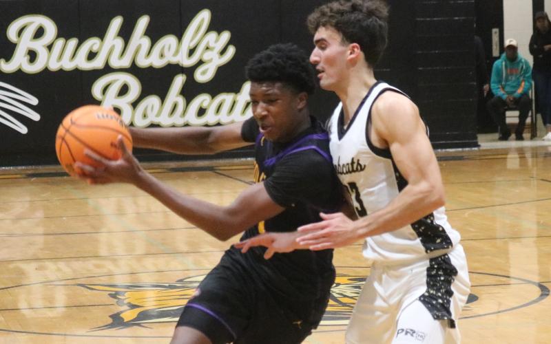 Columbia guard Shaheed White is guarded tightly by Buchholz forward Jamison Mctureous as he drives to the basket on Tuesday. (JORDAN KROEGER/Lake City Reporter)