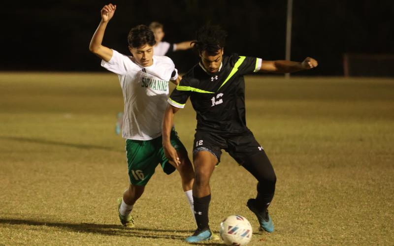 Columbia's Josiah Hopkins gathers possession of the ball while defended by Suwannee's Aksel Perez on Dec. 1. (PAUL BUCHANAN/Lake City Reporter)