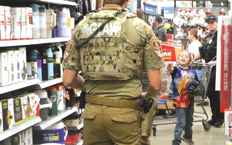 Kenneth Hammett, 7, tries out a new ball and glove in the aisles during last week’s Shop with a Hero event at the Live Oak Walmart. (MORGAN MCMULLEN/Lake City Reporter)