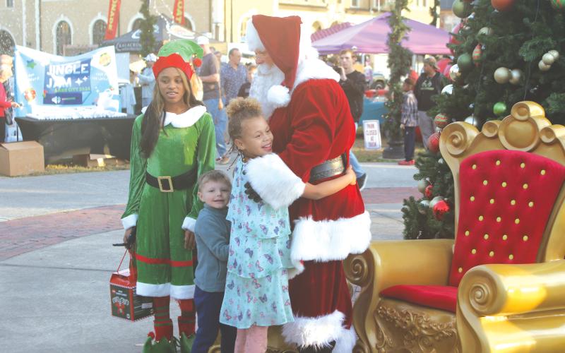 A child hugs Santa Claus at last year’s Light Up the Night Christmas Tree Celebration in Olustee Park. (FILE)