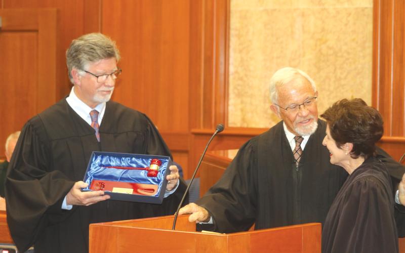 Third Circuit Judge Gregory Parker (from left) and retired Circuit Judge David Fina present retiring Third Circuit Judge Leandra Johnson with a ceremonial gavel during her retirement ceremony Friday. (TONY BRITT/Lake City Reporter)
