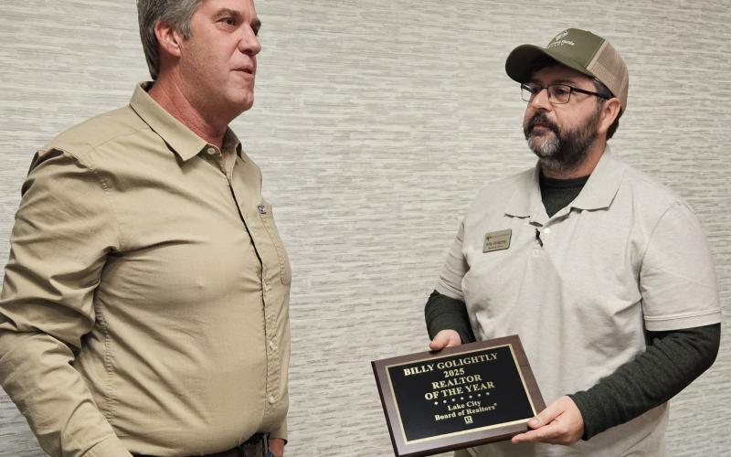 Billy Golightly (right), the broker and co-owner of Lands of North Florida Realty, receives the Lake City Board of Realtors’ Realtor of the Year award Wednesday from Brad Dicks, last year’s winner. (COURTESY)
