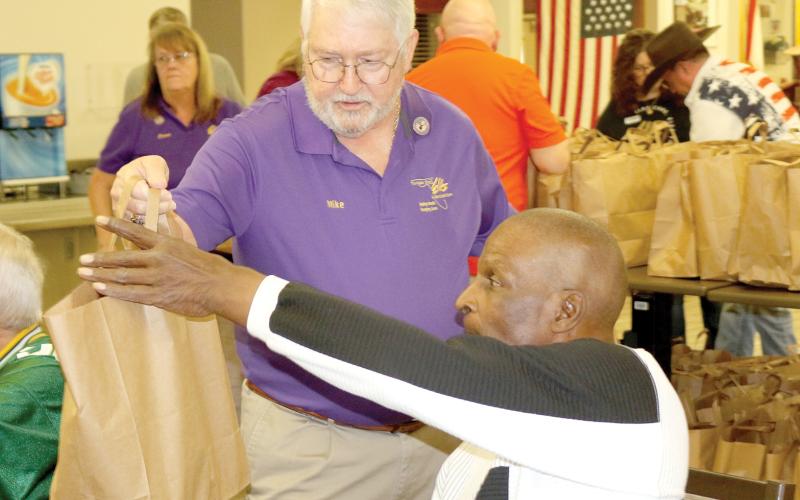 Florida Elks State President Mike Chandler delivers a goodie bag to a veteran at the Robert H. Jenkins VA Domiciliary on Saturday. Chandler was visiting the district Saturday and got to help Lake City Elks Lodge #893 members on the project. (TONY BRITT/Lake City Reporter)