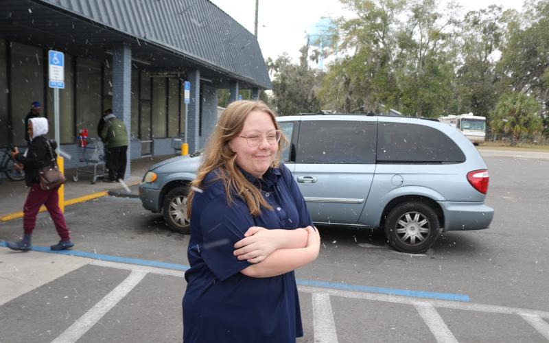 Natalie Fannon, a cashier at Save A Lot In Lake City, checks out the snow flurries that blew through North Florida on Saturday afternoon. (TONY BRITT/Lake City Reporter)