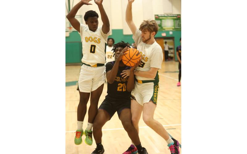 Columbia center Terrance Tolbert (20) looks for an opening to shoot while defended by Suwannee guard Travon Fead (0) and forward Bryson Parlato on Friday. (PAUL BUCHANAN/Lake City Reporter)