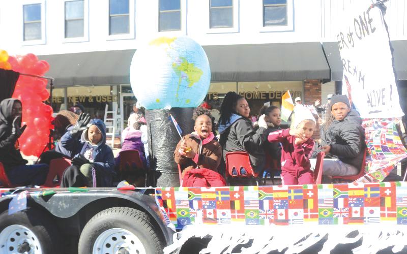 Children on the New Dayspring Missionary Baptist Church float hold flags representing various nations during a previous MLK Day Parade in Lake City. (FILE)