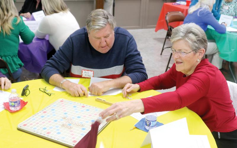 Ferne Mann (right) tosses the bag of letters to other Scrabble players while her tournament partner Mark Kirby looks on during last year’s Lake City Garden Club’s Scrabble Tournament at First Presbyterian Church. (FILE)