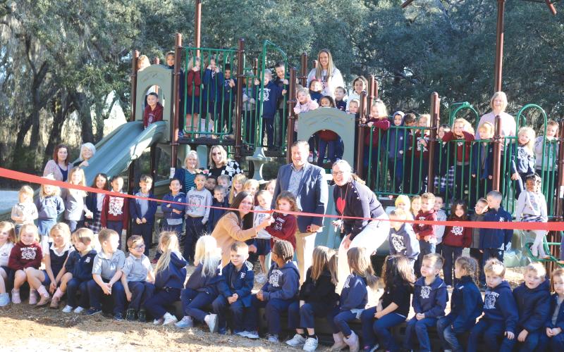 Students and staff at Belmont Academy pose for a ribbon-cutting ceremony during Monday’s debut of their new playground equipment. (TONY BRITT/Lake City Reporter)