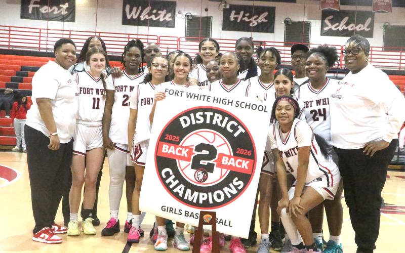 Fort White's girls basketball team displays its banner and trophy after Friday's 64-30 win over Taylor County in the District 6-R championship. (MORGAN MCMULLEN/Lake City Reporter)