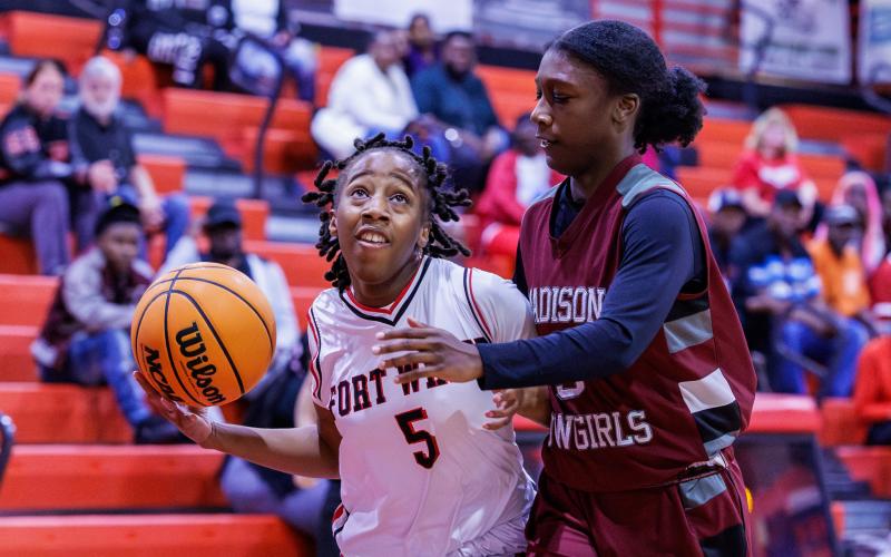 Fort White guard Javiona Roberson drives to the rim against Madison County's Tahj Dobson during Friday's Region 3-R semifinal. (JACK HOWDESHELL/Lake City Reporter)