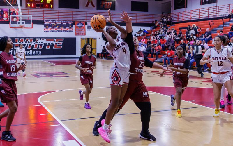 Fort White guard Erickah Roberson fights through a Madison County defender to make the shot during the Region 3-R semifinals on Feb. 13. (JACK HOWDESHELL/Lake City Reporter)
