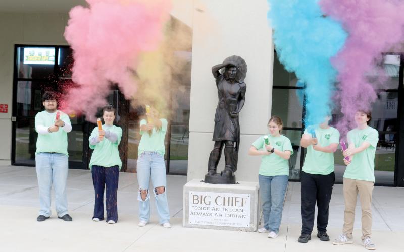 Fort White High School National Honor Society officers Juan Bustamante (from left), Jada Knight, Leah Gianos, Sarah Heeke, Jack Schroader and Cody Maggard shoot off containers of color as they prepare for the school’s annual color fun run which will take place next Saturday. (TONY BRITT/Lake City Reporter)